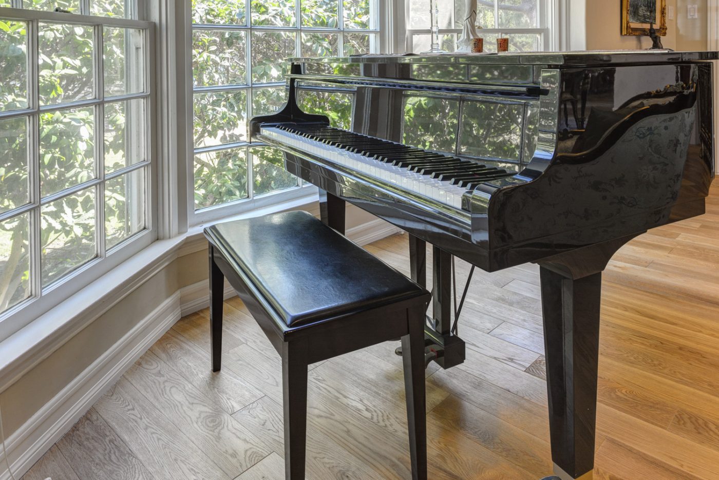 Elegant black grand piano in a bright room, representing piano moving services in NYC.