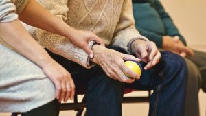 older man holding juggling ball