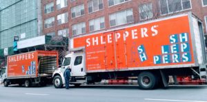 Shleppers moving truck in front of apartment building