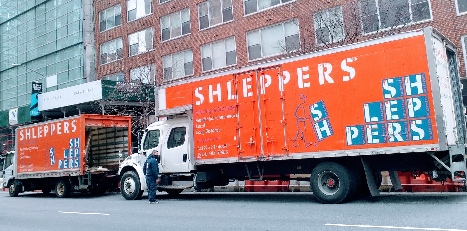 Shleppers moving truck in front of apartment building