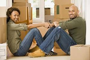 Man and woman sitting by moving boxes