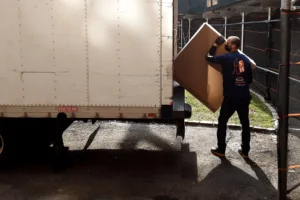 Man moving box into moving truck.