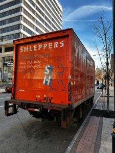 Shleppers moving truck parked outside of a commercial business building