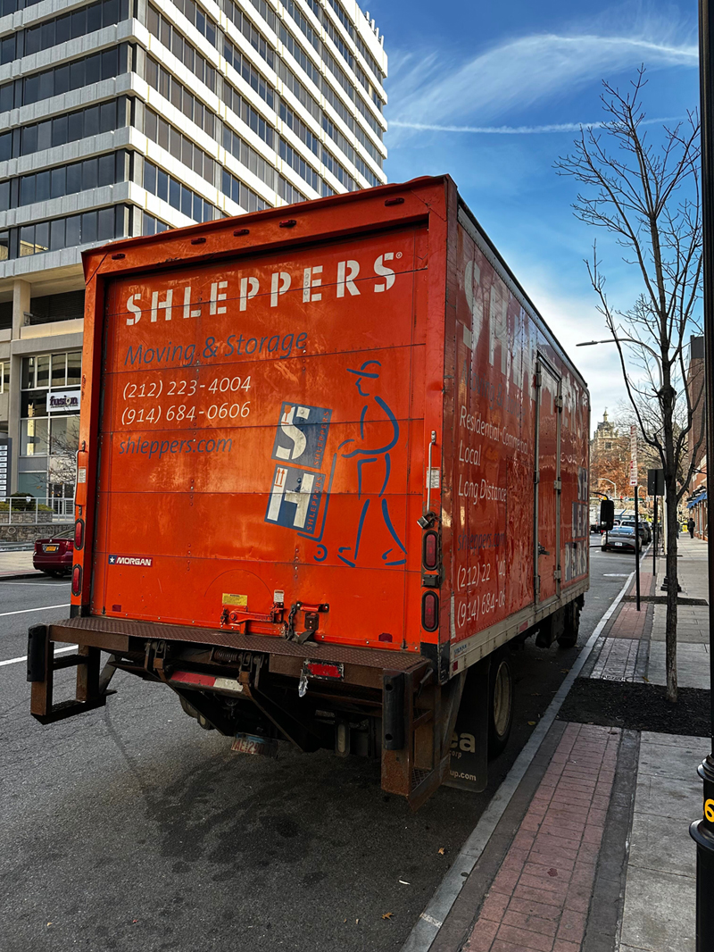 Shleppers moving truck parked outside of a commercial business building