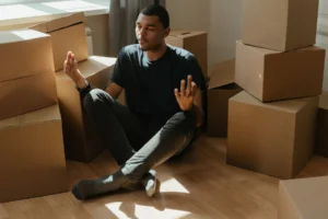 man meditating in between boxes