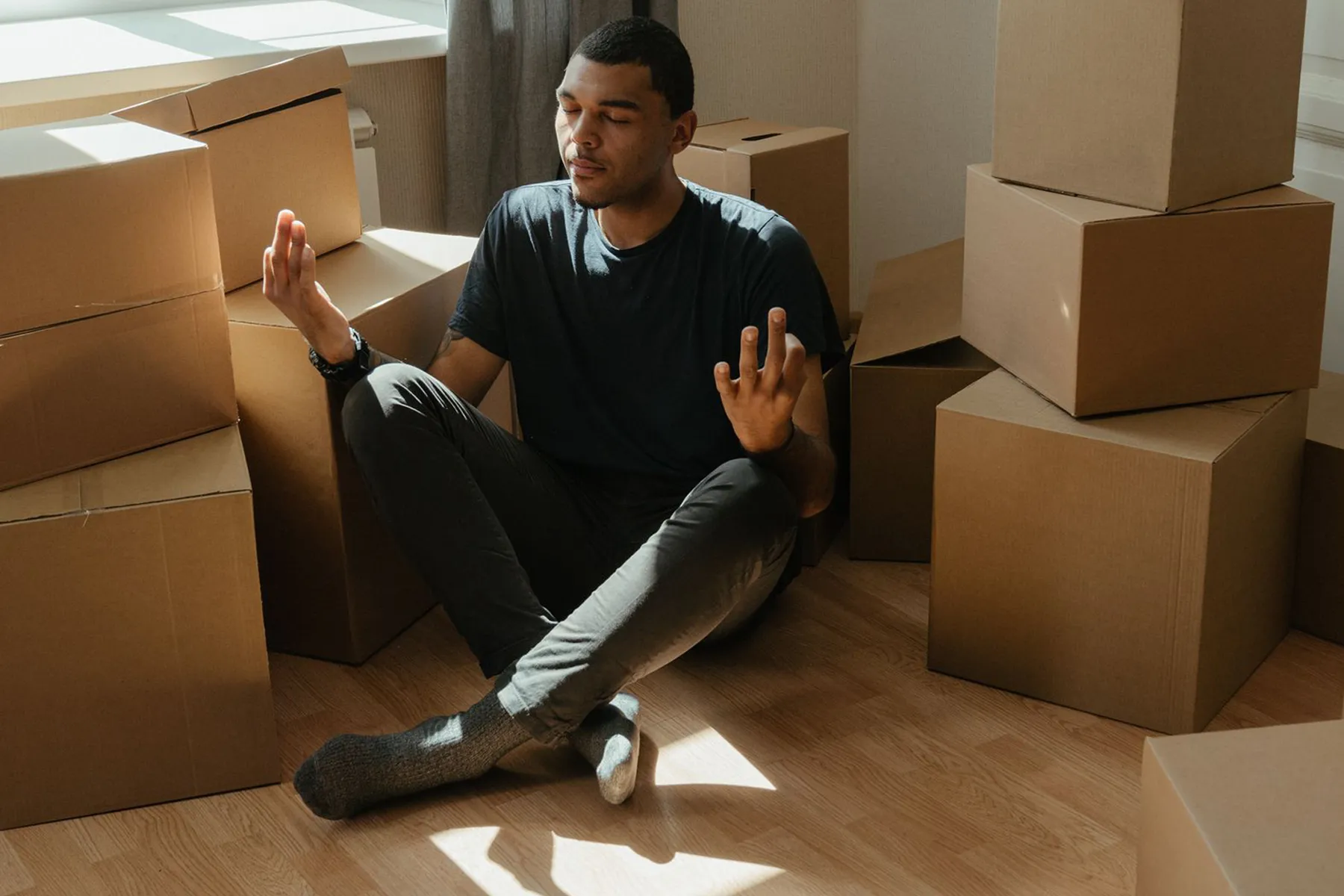 man meditating in between boxes