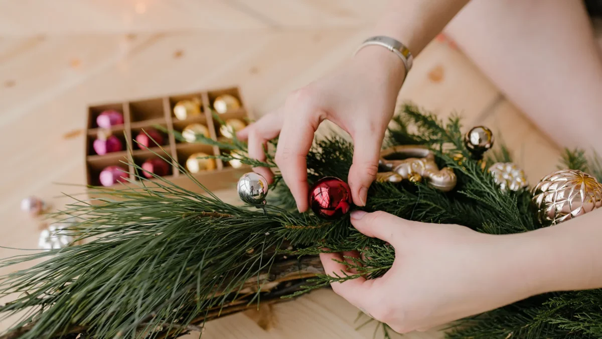 woman's hands creating christmas ornaments and garland